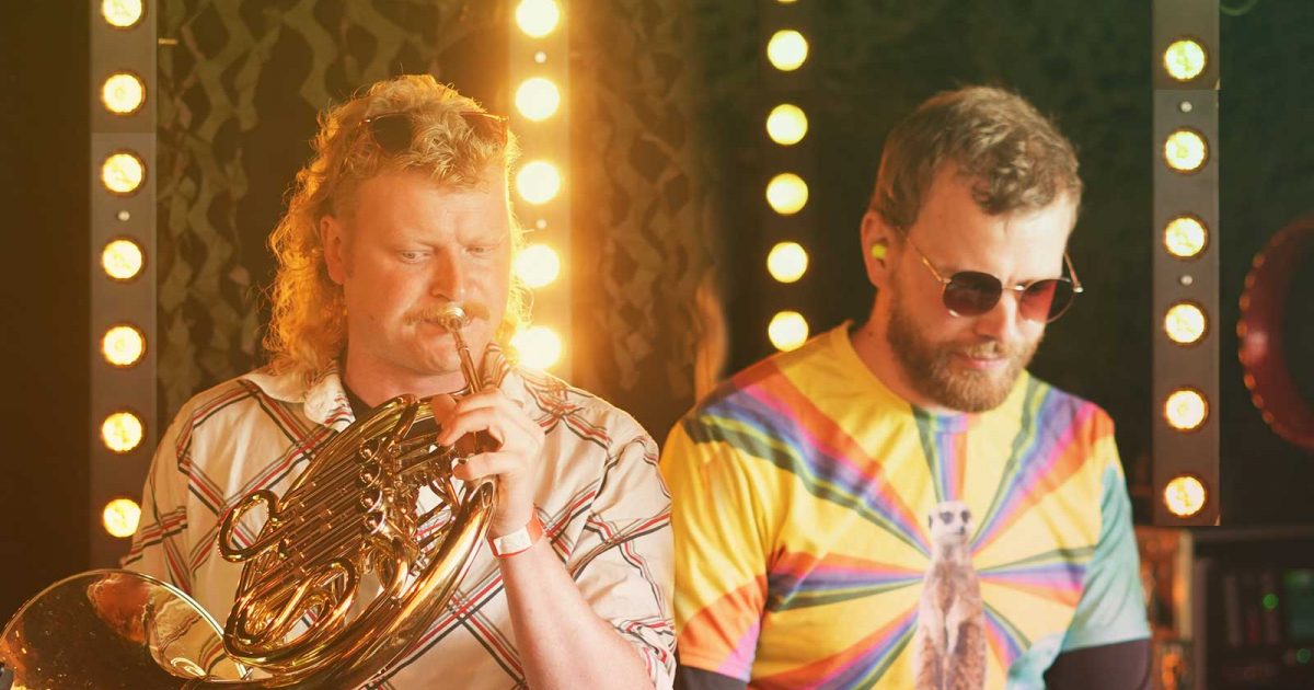 Ingo & Foerb live: Theo spielt Waldhorn, Foerb steht daneben an der Elektronik, dahinter Säulen aus Glühbirnen